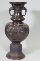 A Japanese Meiji period patinated bronze vase with raised bird decoration and elephant mask handles,