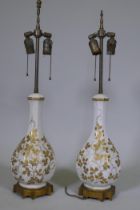 A pair of vintage French Paris porcelain table lamps with gilded decoration, mounted on ormolu bases