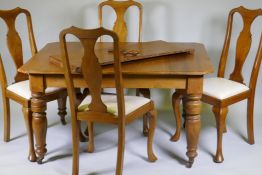 A Victorian walnut wind out dining table with extra leaf and four associated dining chairs, extended