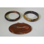 A pair of agate bangles, 16.3cm internal diameter, and an agate pendant in metal mount