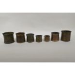 A collection of seven antique Persian bronze measures, of graduated sizes, largest 9cm high x 10cm