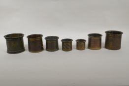 A collection of seven antique Persian bronze measures, of graduated sizes, largest 9cm high x 10cm
