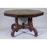 A Victorian oak centre table with octagonal top, raised on four fluted columns and shaped supports