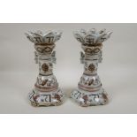 A pair of Chinese red and white porcelain gu shaped candlesticks with scrolling lotus flower and