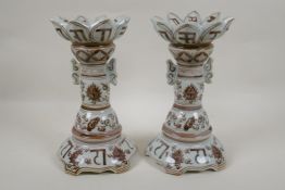 A pair of Chinese red and white porcelain gu shaped candlesticks with scrolling lotus flower and