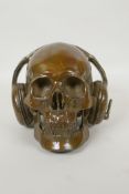 A decorative filled bronze skull wearing headphones, 16cm high