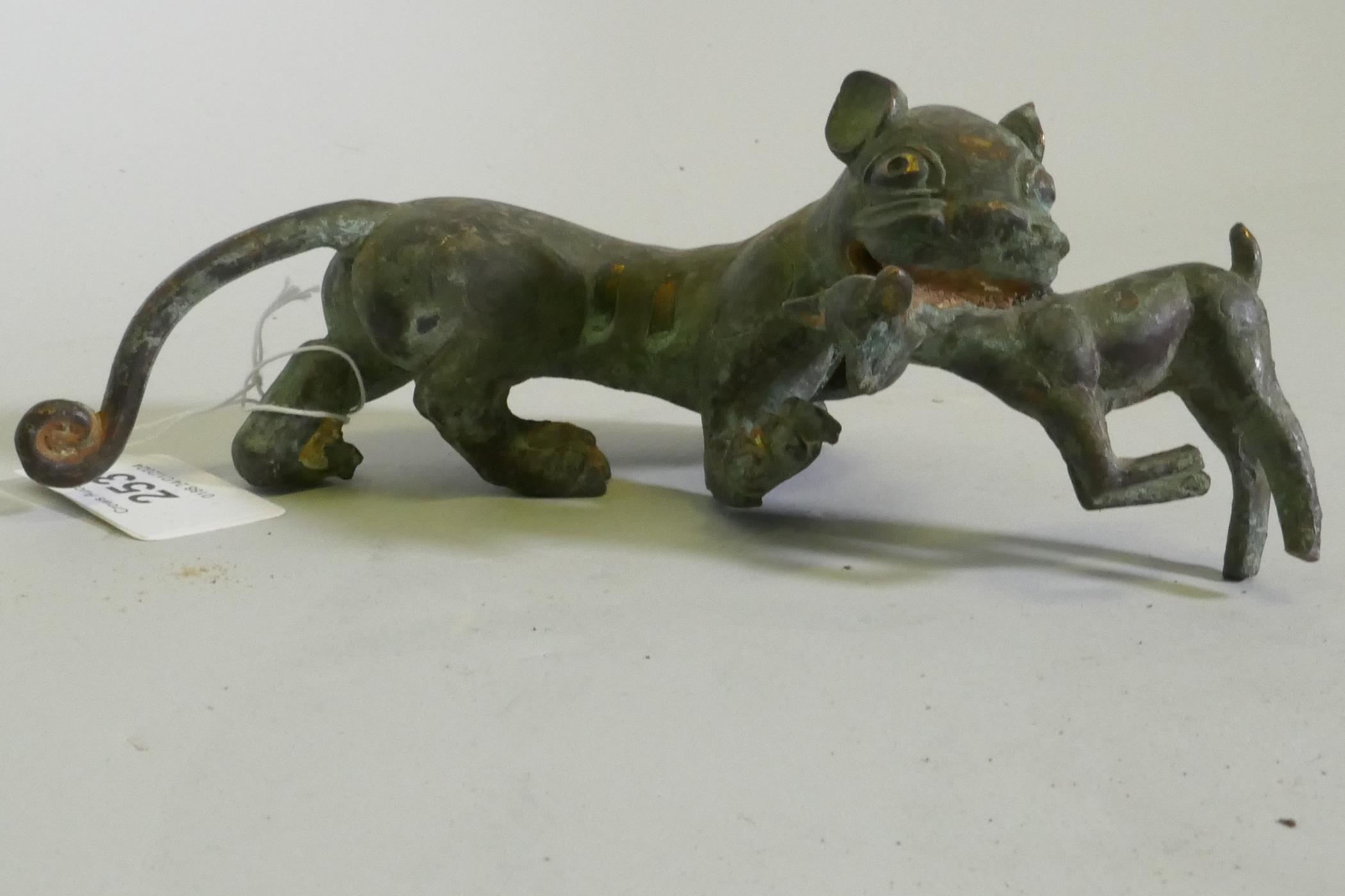 An Eastern bronze figure of a lion with prey, 20 x 7cm high - Image 2 of 4