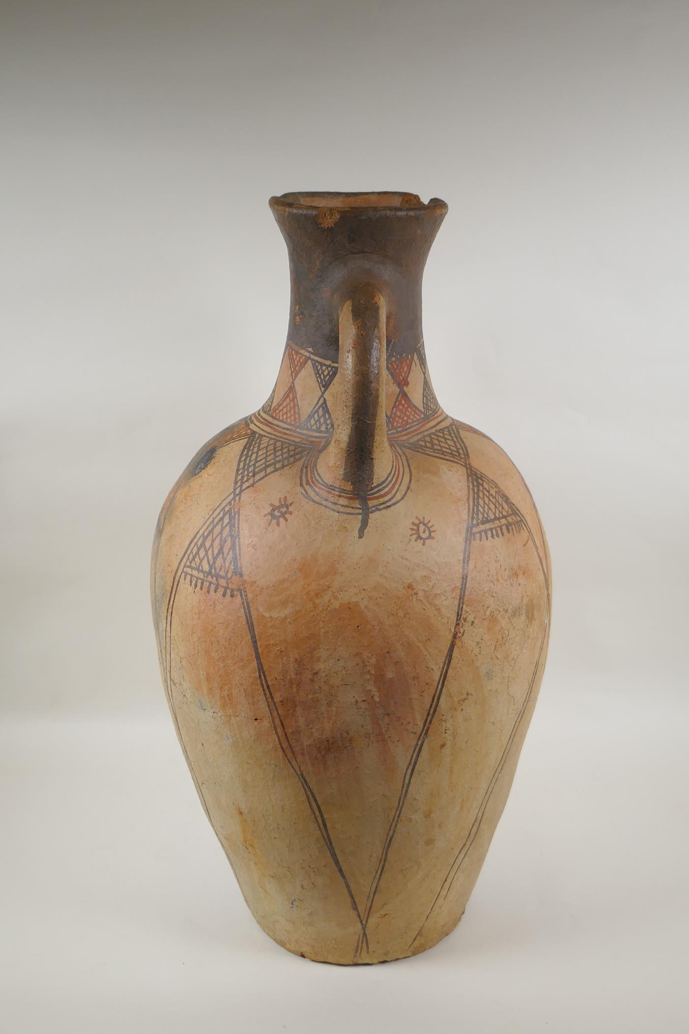 An antique North African terracotta amphora with two handles and hand painted design, AF, 63cm high - Image 2 of 6