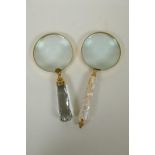 A brass mounted magnifying glass with mother of pearl handle, and another similar with glass handle,