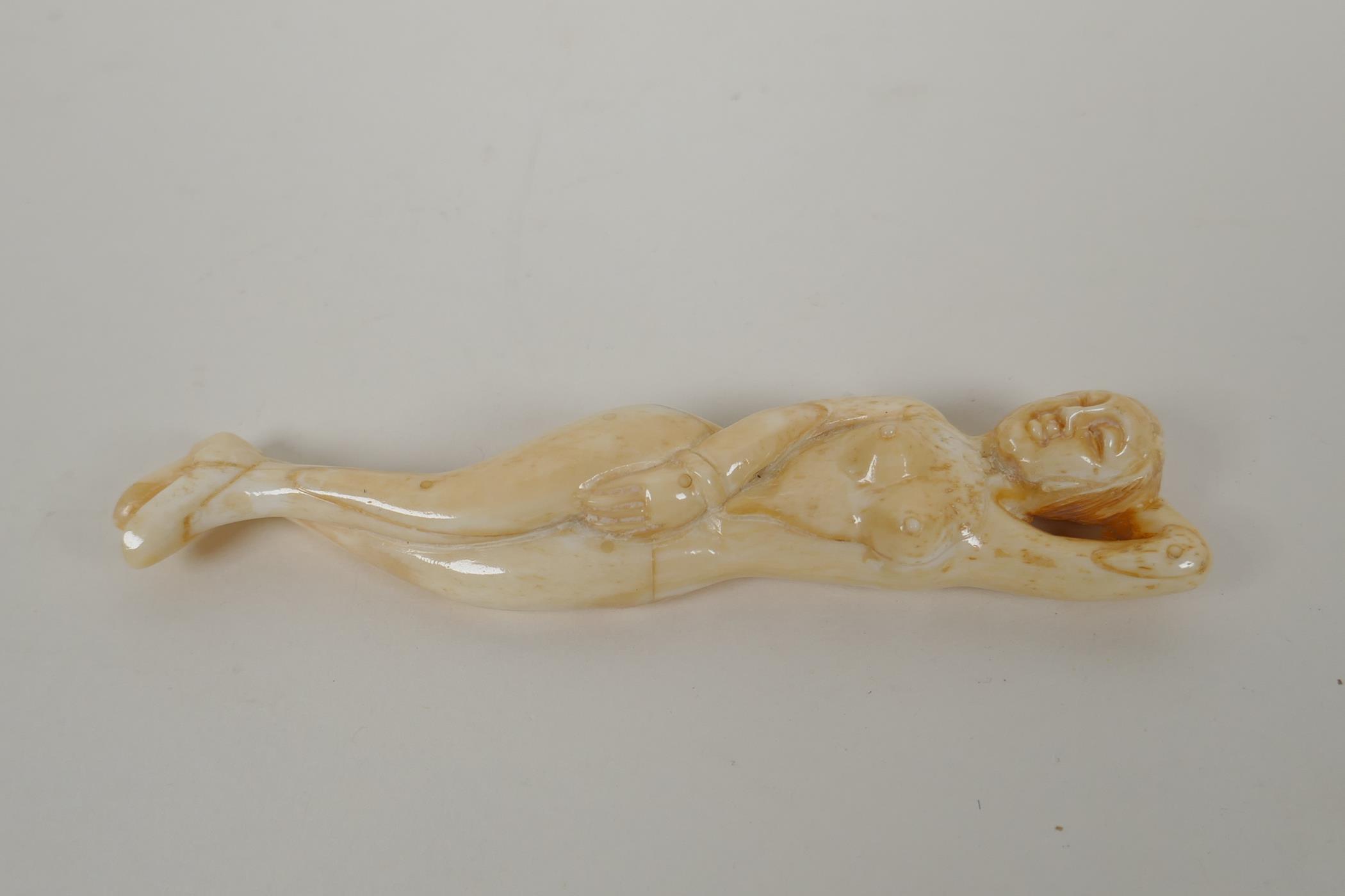 A carved bone figure of a nude, oriental woman, 13cm  long