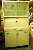 A mid century painted kitchen cabinet with etched sliding doors over a fall front and two cupboards,