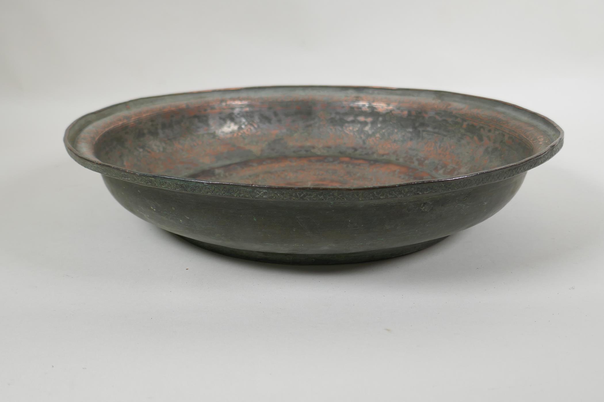 An antique Islamic copper dish with chased script and floral decoration, 34cm diameter - Image 2 of 3