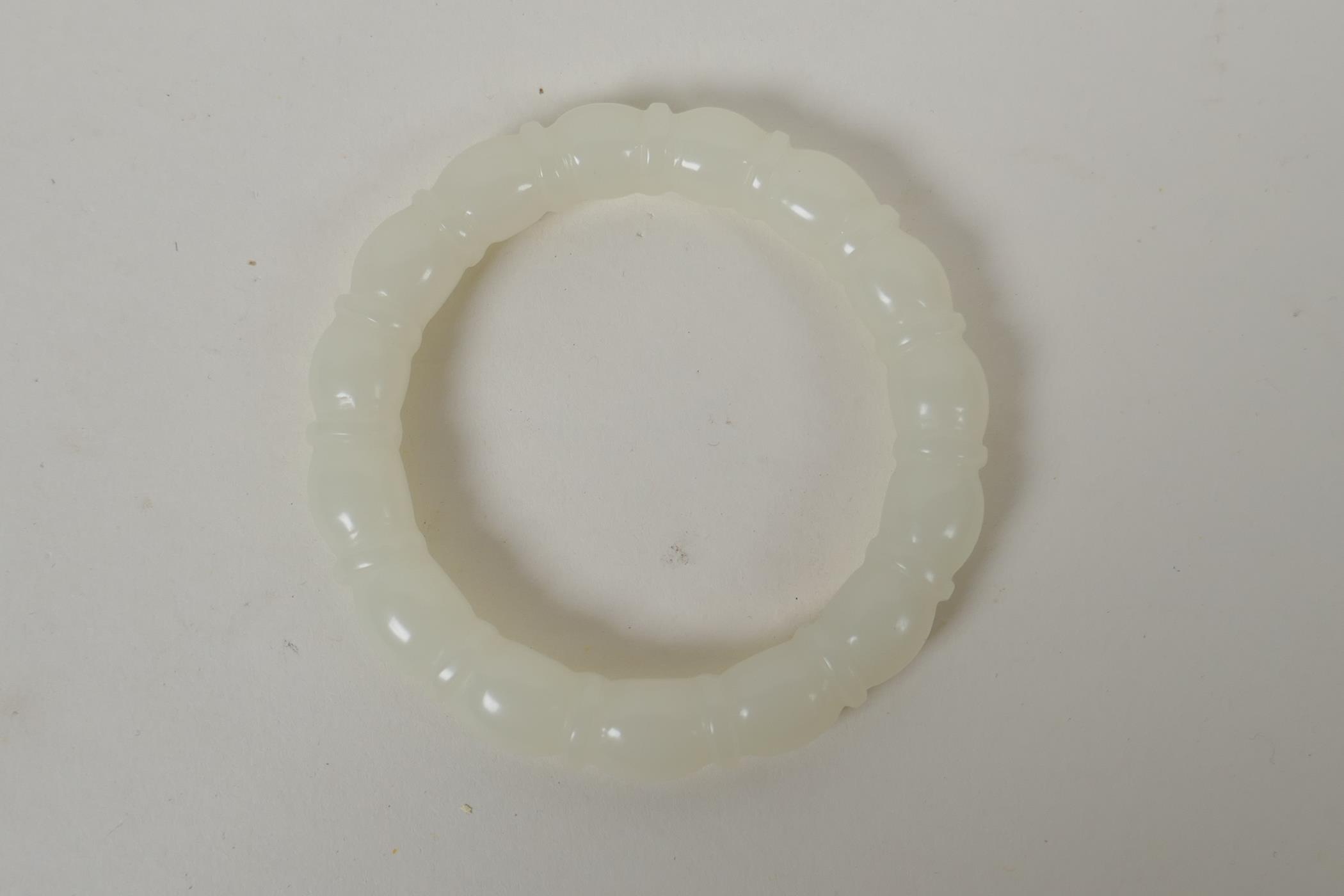 A carved white hardstone bangle, 7.5cm diameter