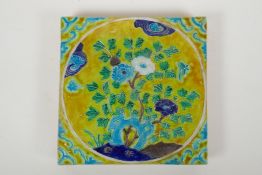 A Chinese yellow ground porcelain temple tile with fahua decoration of flowers, 20 x 20cm