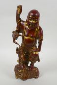A Chinese gilt and copper lacquered bronze figure of Lohan