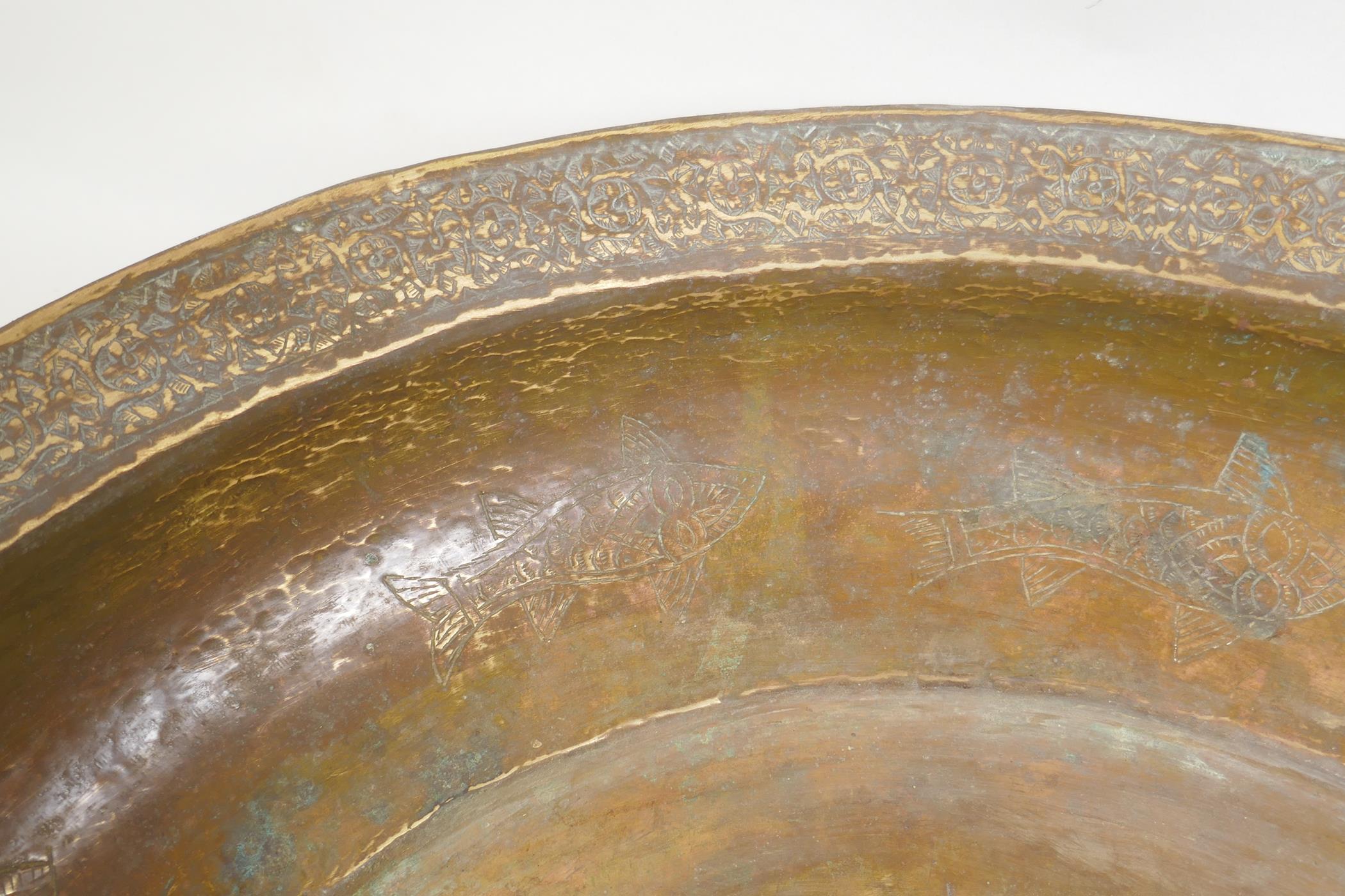 An antique Islamic gilt brass bowl with central boss and chased fish decoration, 46cm diameter - Image 3 of 5