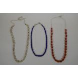 A graduated lapis bead necklace, a string of graduated agate beads and a string of graduated crystal