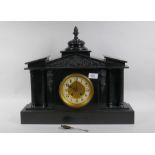 A C19th slate mantel clock of classical form, with carved decoration to the pediment and brass