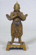A Chinese bronze figure of a warrior god, hands clasped in prayer, impressed seal mark verso, 23cm