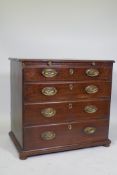 A Georgian mahogany chest of four long drawers under a brushing slide, raised on later bun feet