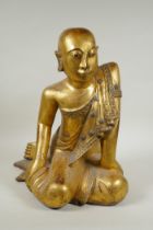 An early carved and gilt Thai figure of a seated Buddha, the robes set with decorative stones,