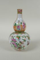 A C19th Chinese Canton famille rose porcelain double gourd vase, with decorative panels depicting