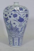 A Chinese blue and white ceramic vase decorated with fish amongst reeds, 42cm high