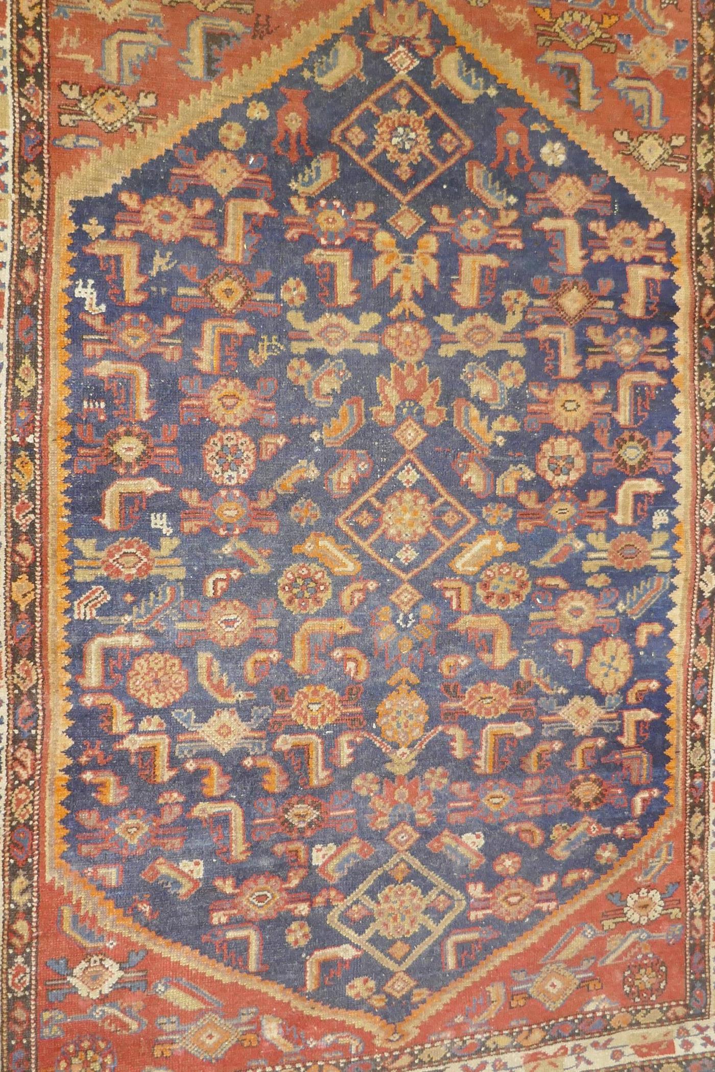 An antique Persian hand woven wool carpet, with medallion design on a red and blue field with - Image 2 of 5