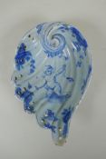 An antique Cantagalli faience blue and white shell shaped dish with putto decoration, 21 x 14cm