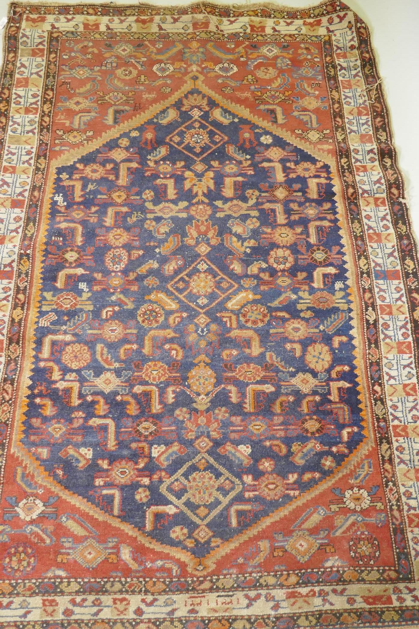 An antique Persian hand woven wool carpet, with medallion design on a red and blue field with - Image 4 of 5