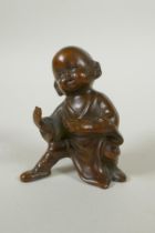 An Oriental bronze figure of a child practising martial arts, 9cm high