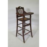 An oriental hardwood child's highchair with can back and seat, 103cm high