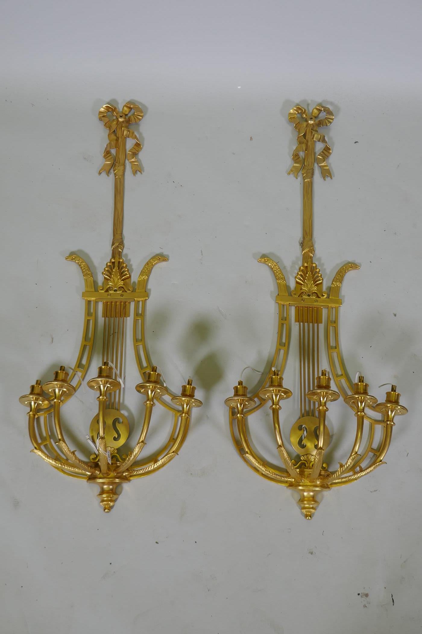 A pair of ormolu empire style five branch wall sconces of lyre form, 97cm high