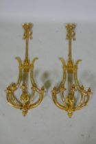 A pair of ormolu empire style five branch wall sconces of lyre form, 97cm high