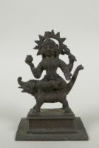 An antique Indian bronze figure of Durga riding a mythical creature, 12cm high