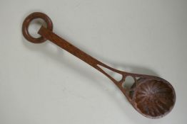 A Welsh hand carved and pierced fruit wood love spoon, 28cm long
