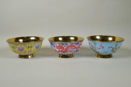 Three Chinese polychrome porcelain bowls with gilt lustre interiors, decorated with flowers, peaches