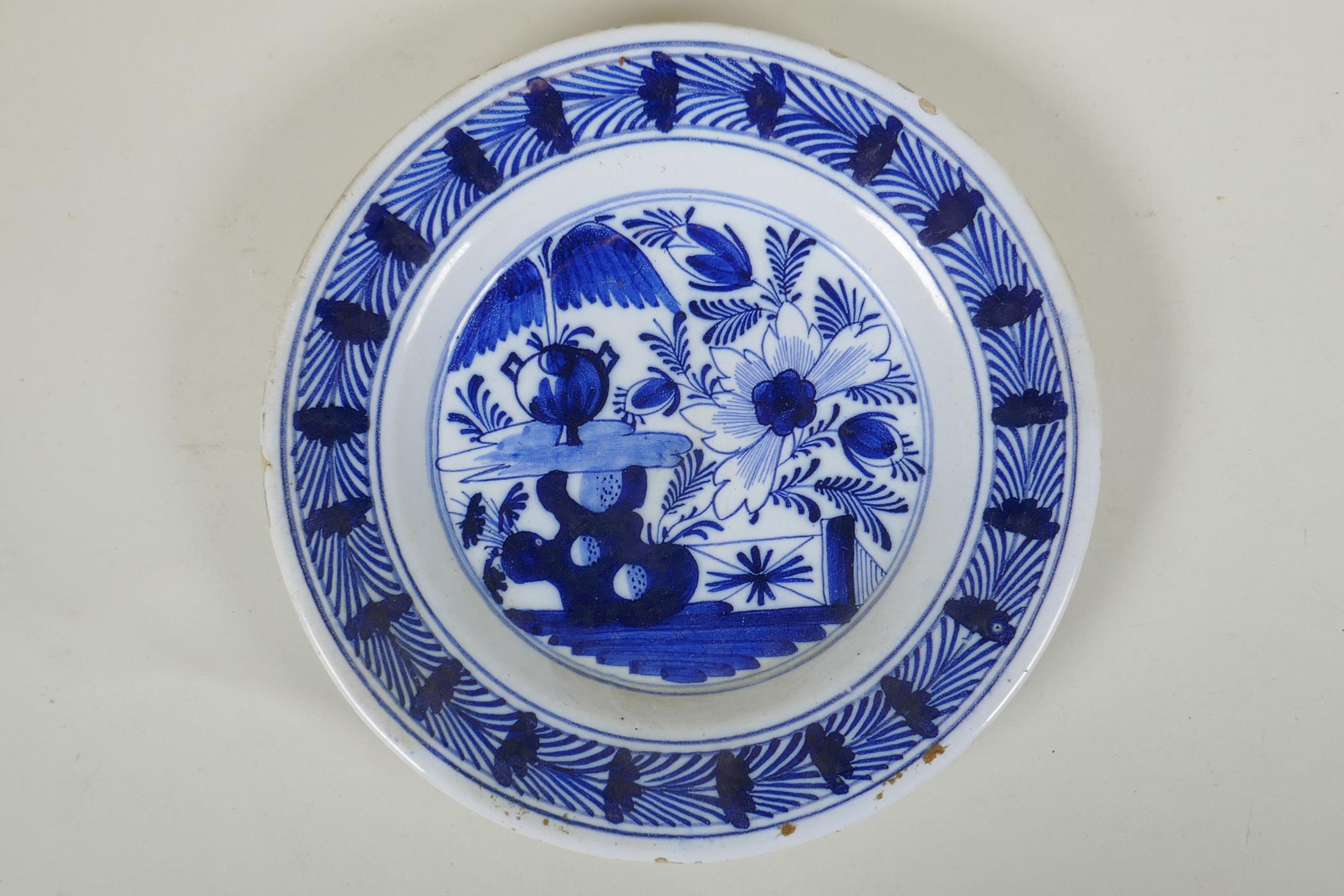 An C18th Dutch Delft blue plate with floral decoration, 23cm diameter