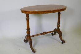 A Victorian walnut stretcher table, oval top raised on turned end columns with carved cabriole