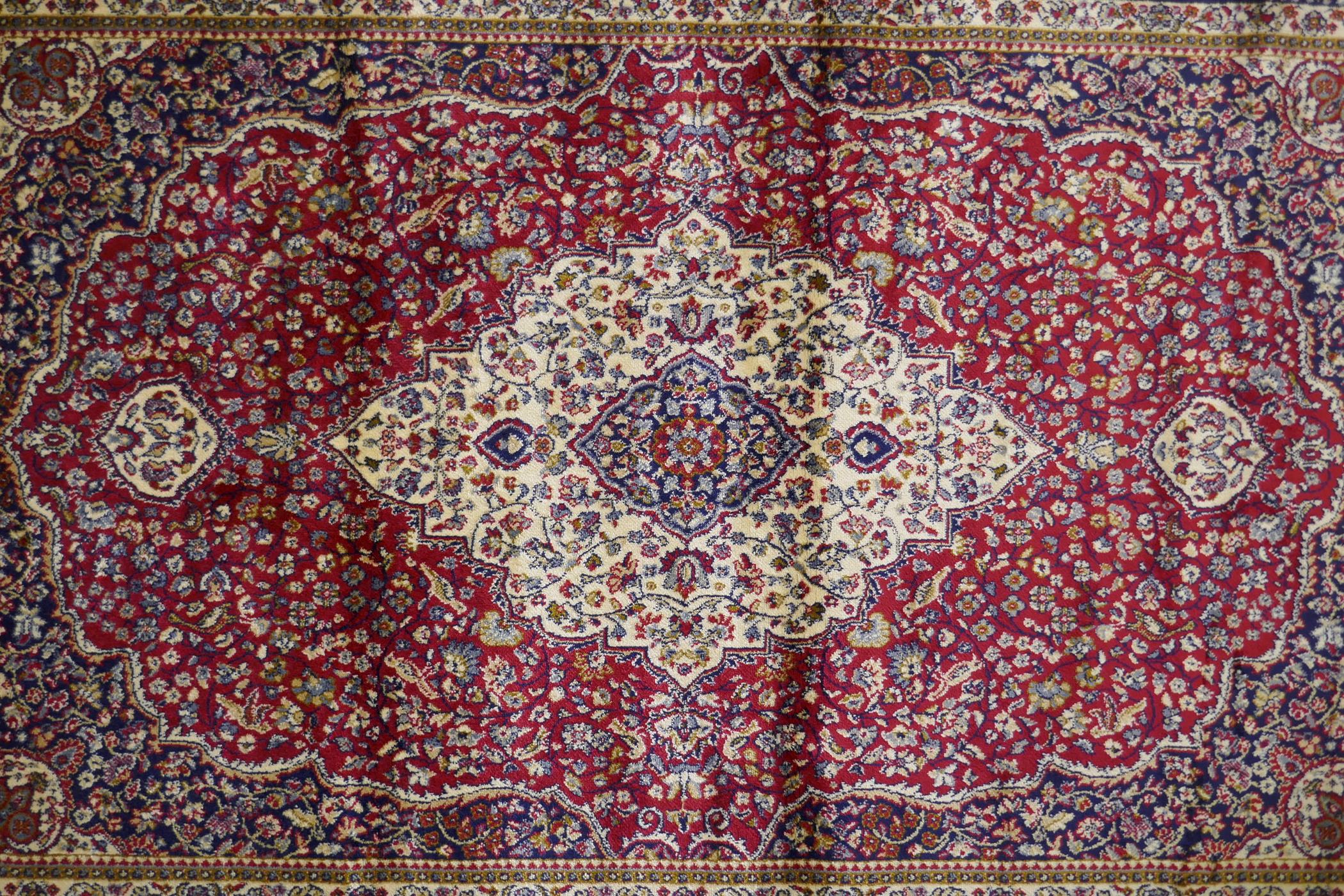 A red ground Kashmir rug with traditional floral medallion design and blue borders, 170 x 120cm - Image 3 of 5