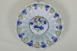 A C17th/C18th English Delft fluted dish, with floral decorated to centre, AF, 22cm diameter