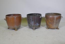 A near pair of copper planters/jardinieres of rivetted construction, raised on paw feet, and another
