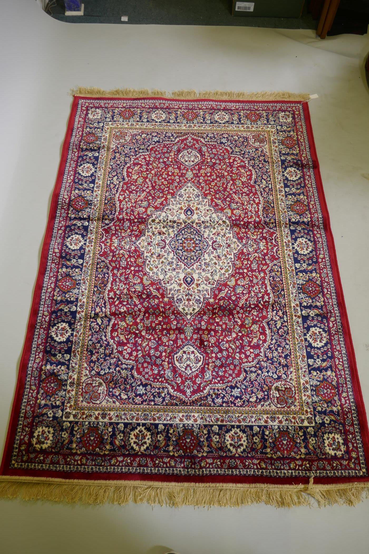 A red ground Kashmir rug with traditional floral medallion design and blue borders, 170 x 120cm - Image 2 of 5