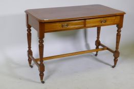 A Victorian mahogany two drawer writing table, raised on tapering supports untied by an H stretcher,