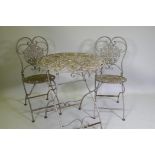 A painted and distressed metal bistro table and two folding chairs, 69cm diameter