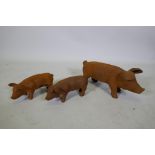 A cast iron garden figure of a sow and two smaller piglets, largest 42cm