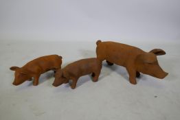 A cast iron garden figure of a sow and two smaller piglets, largest 42cm