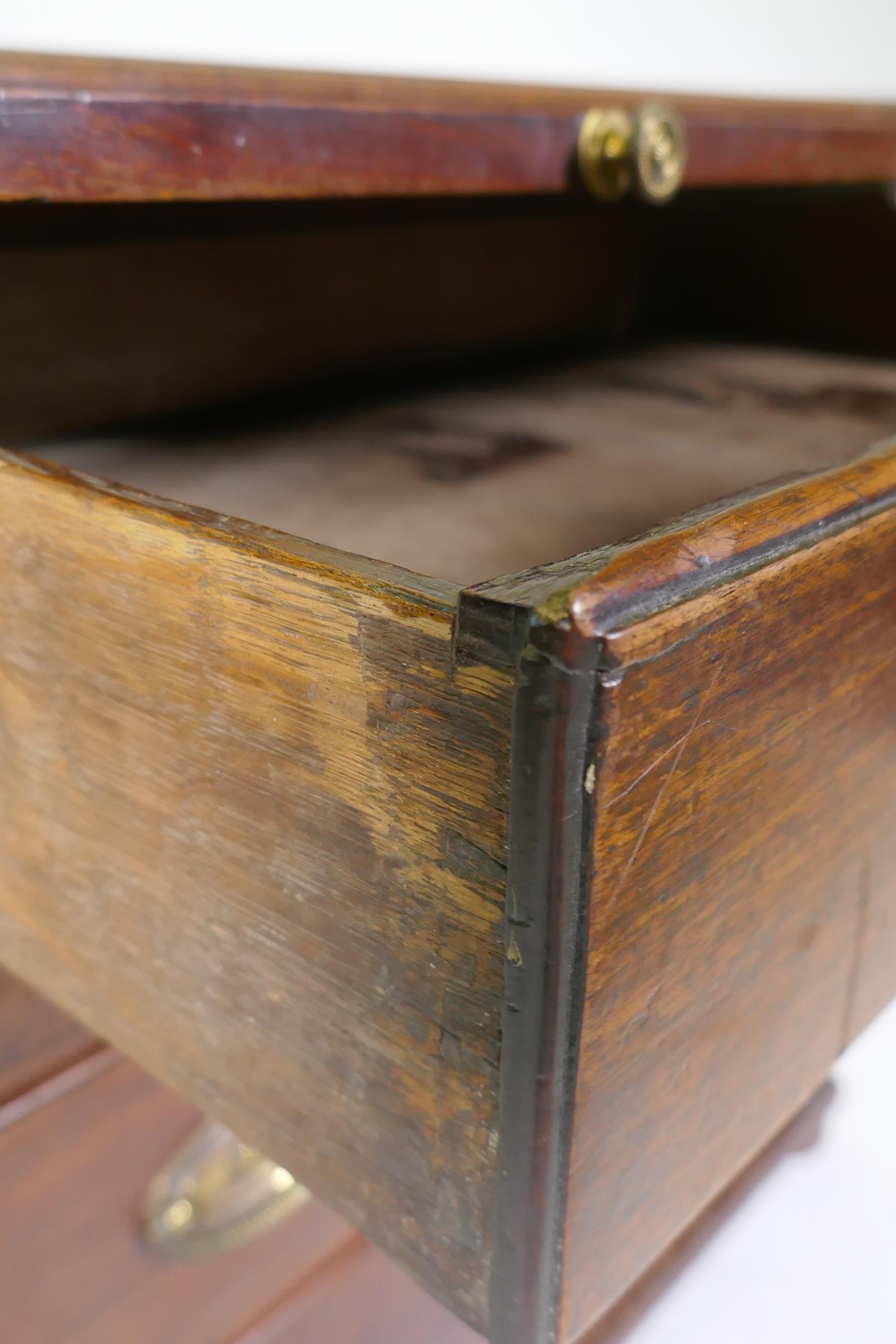 A Georgian mahogany chest of four long drawers under a brushing slide, raised on later bun feet - Image 4 of 5