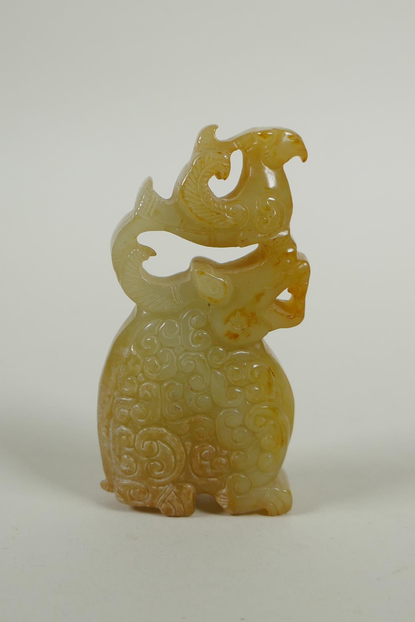 A Chinese carved and pierced jade pendant decoration with kylin and phoenix, 8cm high
