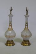 A pair of cut and etched glass table lamps with gilt and enamel decoration, a brass bases, 67cm high